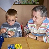 Seniorin und Kind spielen konzentriert am Tisch; (c) Schulen ans Netz e. V. (BIBER)