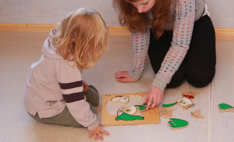 Kind mit Erzieherin beim Puzzeln;  (BIBER) Schulen ans Netz