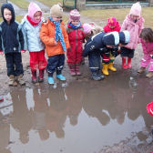 Kinder spiegeln sich in einer Pfütze; © (BIBER) Schulen ans Netz