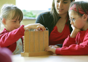 Kinder mit einer Perlen-Rechenmaschine   Natur-Wissen schaffen