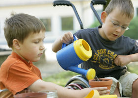 Kind fllt Wasser in einen Blumentopf,  Natur-Wissen schaffen