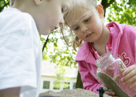 Mdchen experimentiert mit Sand und Waage;  Natur-Wissen schaffen